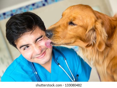 Söt hund som ger en kyss till veterinären efter en kontroll Stockfoto