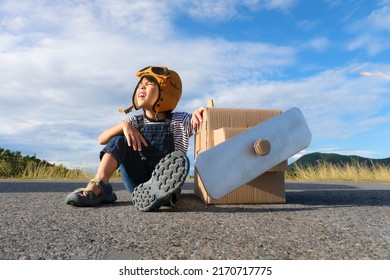 Cute dreamer little girl playing with cardboard planes on a lake road on a sunny day. Happy kid playing with cardboard plane against blue summer sky background. Childhood dream imagination concept. - Shutterstock ID 2170717775