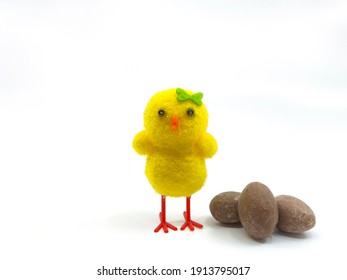 Cute Easter Chick With Small Chocolate Easter Eggs On A Plain Background. No People. Copy Space..