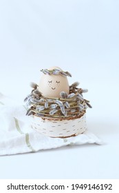 Cute Easter egg in decorative nest on white table. Space for text.