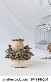Cute Easter egg in decorative nest on white table. Space for text.