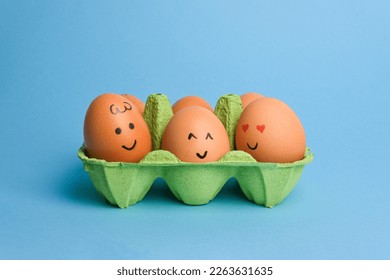 Cute easter eggs with funny faces in green box isolated on blue background. Happy easter concept. - Powered by Shutterstock