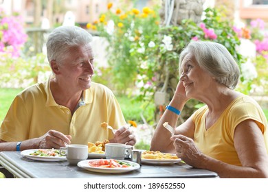 Cute Elder Couple Eating Breakfast  In Summer Outdoors