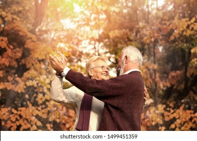 Cute Elderly Couple Dancing In Autumn Day