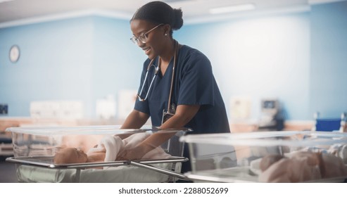 Cute Emotional Newborn Little Infant Lying in Hospital Cot. Young Black Pediatrician Taking Care of the Baby and Fixing the Blanket. Healthcare, Pregnancy and Motherhood Concept - Powered by Shutterstock