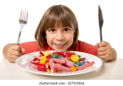 Cute European Female Child Smiling Happy Eating Candy With Spoon Fork And Knife In Sugar Abuse , Unhealthy Sweet Nutrition Concept , Children Candy Addiction And Kids  Dental Care