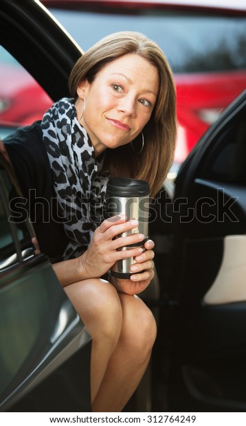 Cute executive\
sitting in car with open\
door