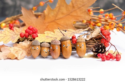 Cute Family Of Acorns In Hats, Funny Emotion Faces. Children's Creativity, DIY Idea For Fall Season. Acorns, Berries And Oak Leaves, Symbol Of Autumn