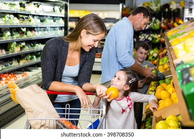 Cute family choosing groceries together in the supermarket