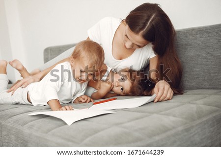 Similar – Mother reading book to her sons in the bed