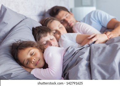 Cute family sleeping together in bed