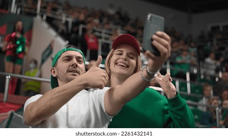 Cute fans couple take selfie photo sport soccer stadium. Happy emotion lovers enjoy romantic love date. Smile guy man win football bet. Romance joy together. Fun girl shot selfies blog mobile phone. - Powered by Shutterstock