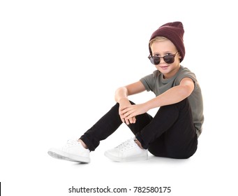 Cute fashionable boy sitting on white background
