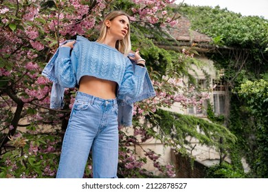 Cute Fashionable, Feminine  Blonde With Short Sweater Revealing Her Stomach, Posing Next To Blooming Tree 