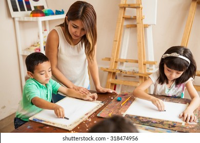 Cute Female Art Teacher Helping Her Students Draw At An Art School