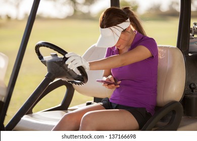 Cute female golfer doing some social networking on her cell phone