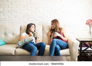 Cute Female Roomates Relaxing At Home And Drinking Coffee Together