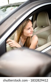 Cute Female Teen Driver Enjoying Her Freshly Acquired Driving License At The Wheel Of Her First Car