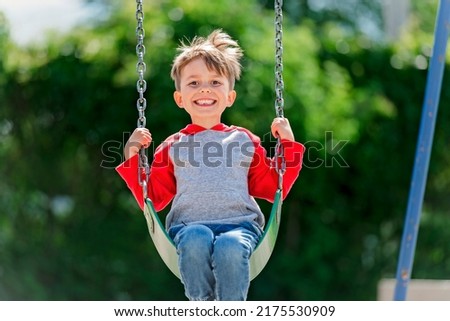 A cute five year old boy outside portrait on the playground