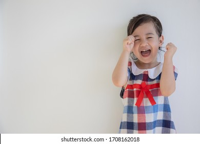 A cute four-year-old asian girl is smiling and acting with the camera. Anyone who sees will feel bright and happy. Photos in the studio on a white background for half body shot with copy space. - Shutterstock ID 1708162018