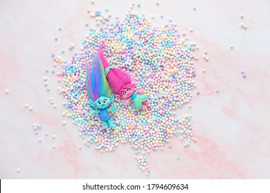 cute friends trolls with gentle colorful balls decor on pink background. Harper Pinsel and Queen Poppy - modern toy hasbro trolls. concept of children's games, fun, toys, friendship. flat lay