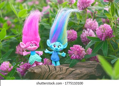 cute friends trolls on summer floral meadow, natural background. Harper Pinsel and Queen Poppy - modern toy hasbro trolls. concept of children's games, fun, toys, friendship