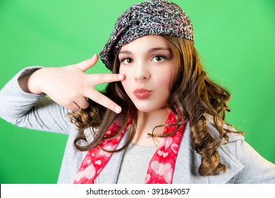 Cute, fun, and stylish caucasian tween girl peace gesture on green screen