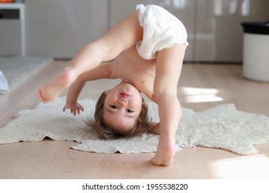 Cute And Funny Baby Boy Wearing Diaper Bending Over Doing Yoga Or Playing Hide And Seek At Home. Happy Mixed Race Asian-German Child Play And Learn Development.