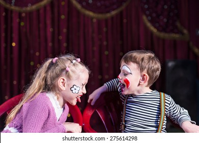 Cute funny boy and girl with painted faces acting as a couple with communication problems, during a theatrical performance