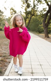 Cute Funny Child Girl 4-5 Year Old Wear Bright Pink Sweater Having Fun Playing In Park Outdoor. Childhood. Autumn Season. 