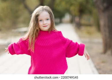 Cute Funny Child Girl 4-5 Year Old Wear Bright Pink Sweater Having Fun Playing In Park Outdoor. Childhood. Autumn Season. 