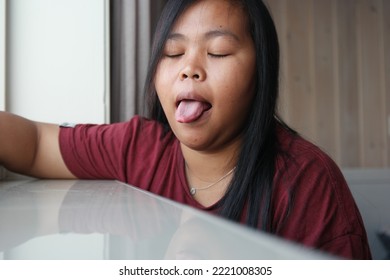 Cute And Funny Face Of Asian Woman Sticking Out Her Tounge 