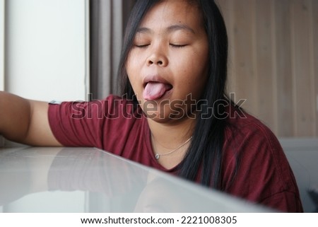 Cute and funny face of asian woman sticking out her tounge 