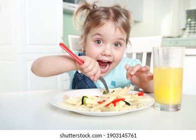 Cute Funny Kid Eating Noodles.Little Girl Have A Meal.Happy Preschooler Lifestyle Portrait.