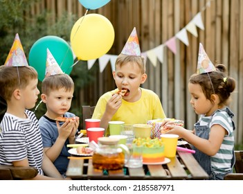 Cute Funny Nine Year Old Boy Celebrating His Birthday With Family Or Friends And Eating Homemade Baked Pizza In A Backyard. Birthday Party For Kids