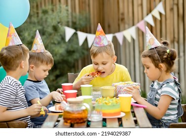 Cute Funny Nine Year Old Boy Celebrating His Birthday With Family Or Friends And Eating Homemade Baked Pizza In A Backyard. Birthday Party For Kids