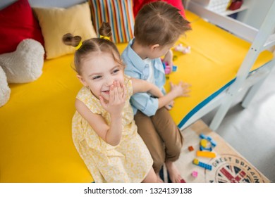 cute funny smiling fair-haired children of 6-8 years old play the constructor on a bright bed and cannot share it, rob each other details