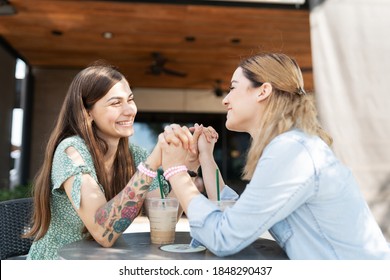 Cute Gay Couple Holding Both Their Hands Together At The Table And Making Eye Contact