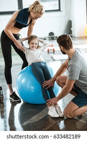 Cute Gir Exercising On Swiss Ball With Parents