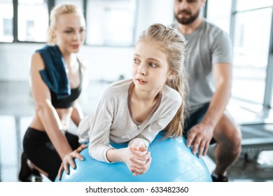 Cute Gir Exercising On Swiss Ball With Parents