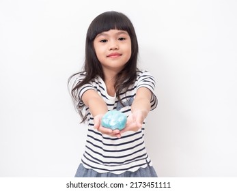 Cute girl 6 year old holding a blue slime and exited. Studio isolated on white background. - Shutterstock ID 2173451111