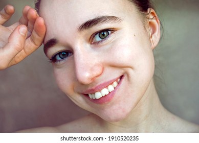 A cute girl  blond without makeup. Smiles and looks at the camera. Natural appearance. 
