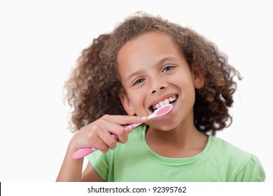 Cute girl brushing her teeth against a white background - Shutterstock ID 92395762