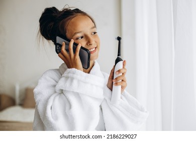 Cute Girl Brushing Teeth And Using Phone