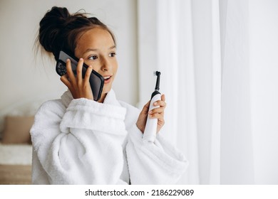 Cute Girl Brushing Teeth And Using Phone