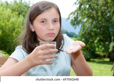 Cute Girl Child Taking Pill With Glass Of Water