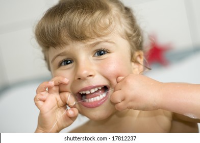 Cute Girl Cleaning Teeth By Floss In Bath