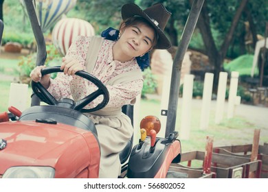 A Cute Girl Is Driving A Tractor In The Sheep Fram.