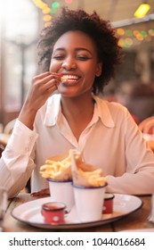 Cute Girl Eating French Fries In A Bar