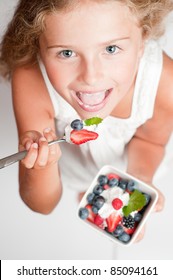 Cute girl eating fresh berries